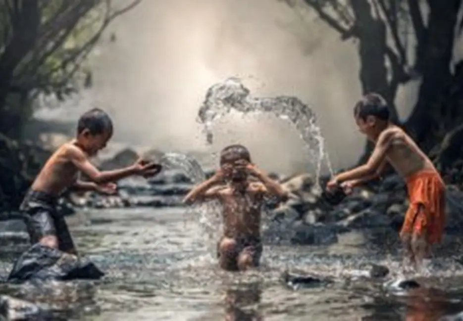 Kids playing in creek, splashing water.