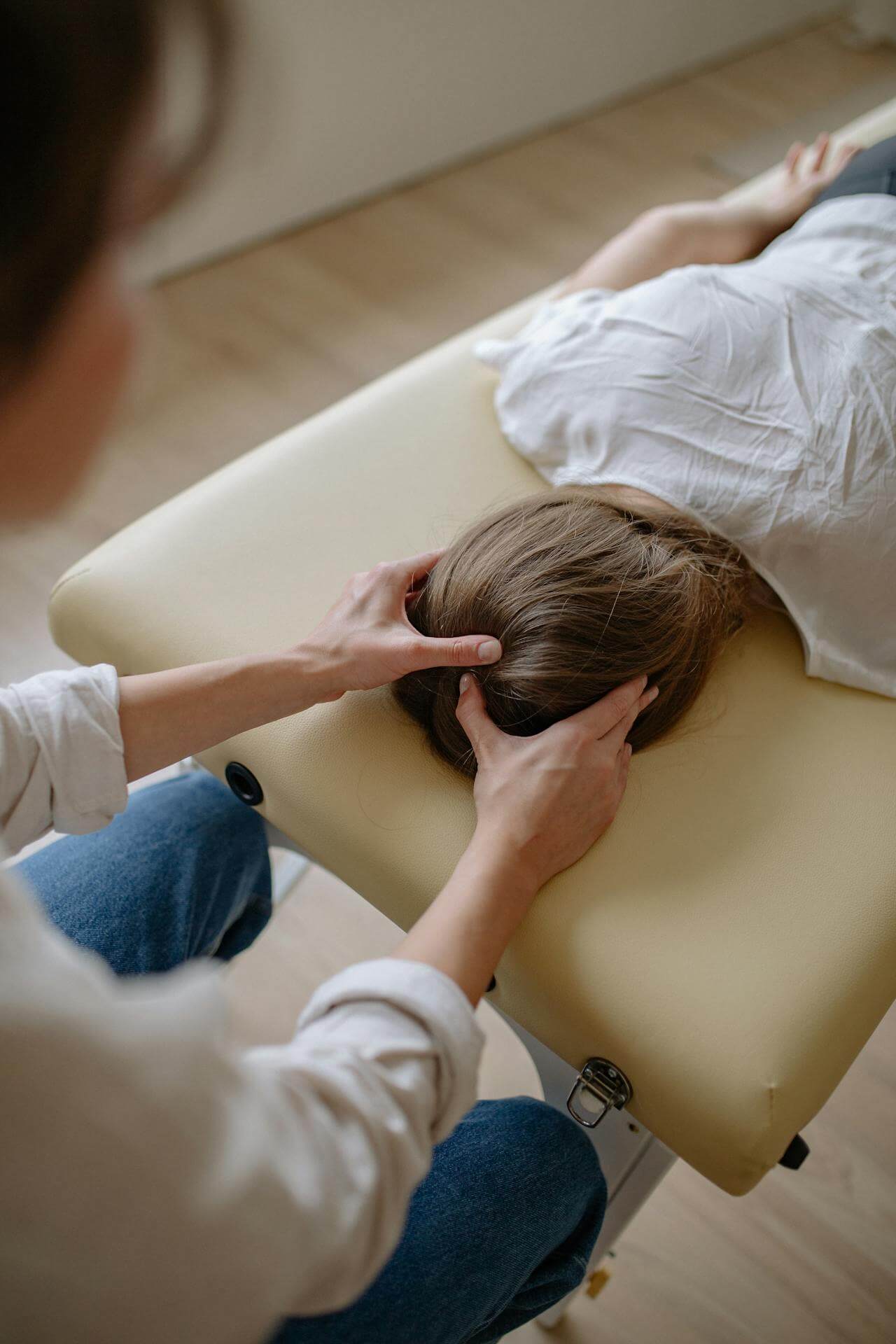 Doctor and female patient who is laying down during a holistic care session.