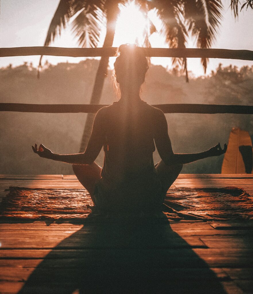 Woman sitting in yoga pose, concentrating on wellness.